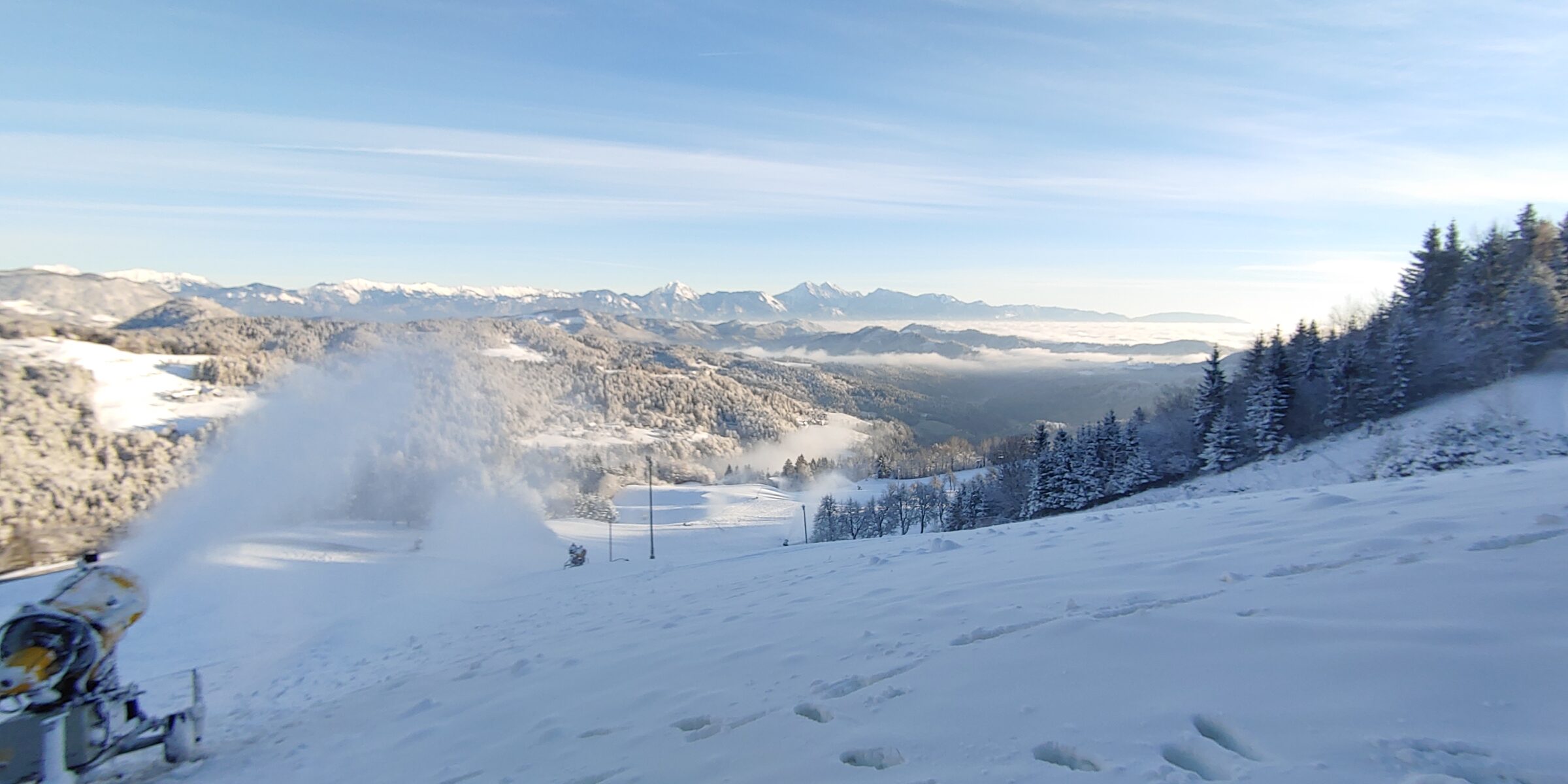 Pogled s Starega vrha na zasnežene proge in Kamniško-Savinjske Alpe